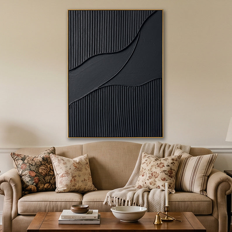Wavy black 3D textured wall art hanging in a cozy living room over a light tan couch.