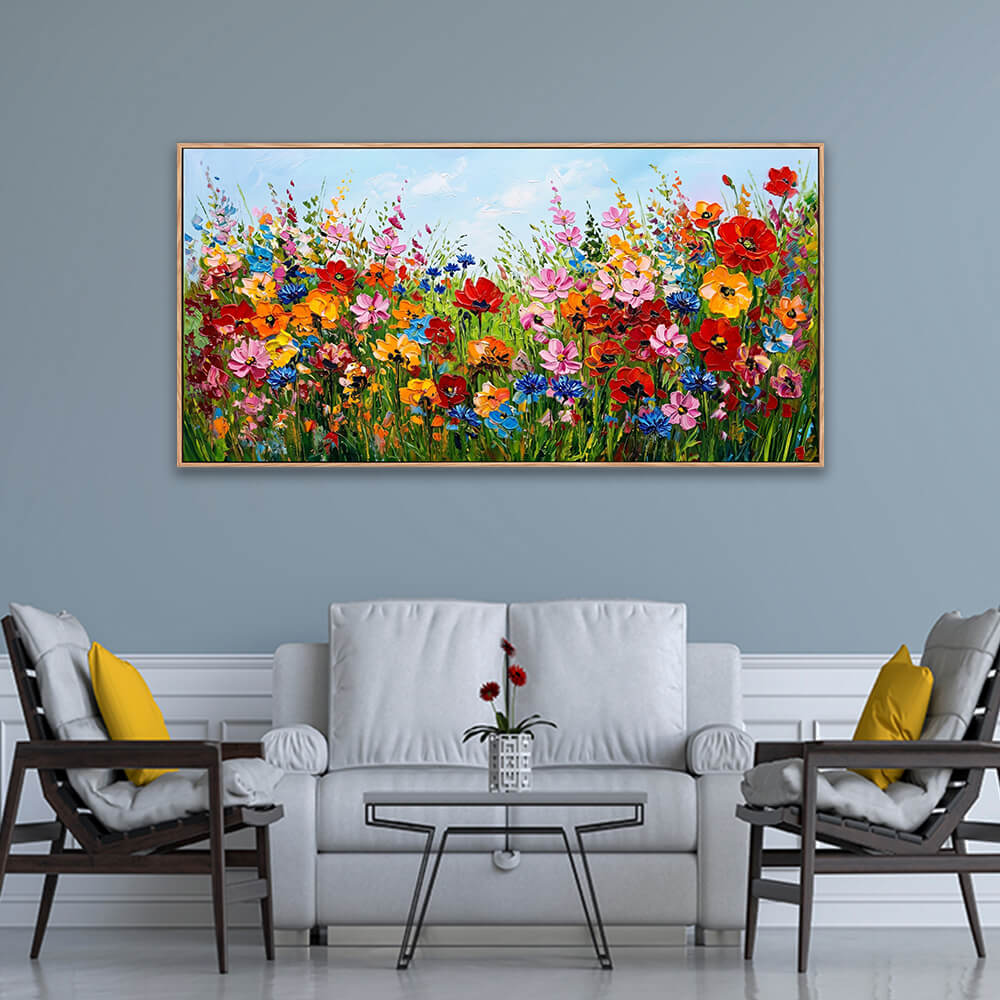 Panoramic colorful floral meadow painting with textured wildflowers and a soft blue sky styled on a neutral wall.